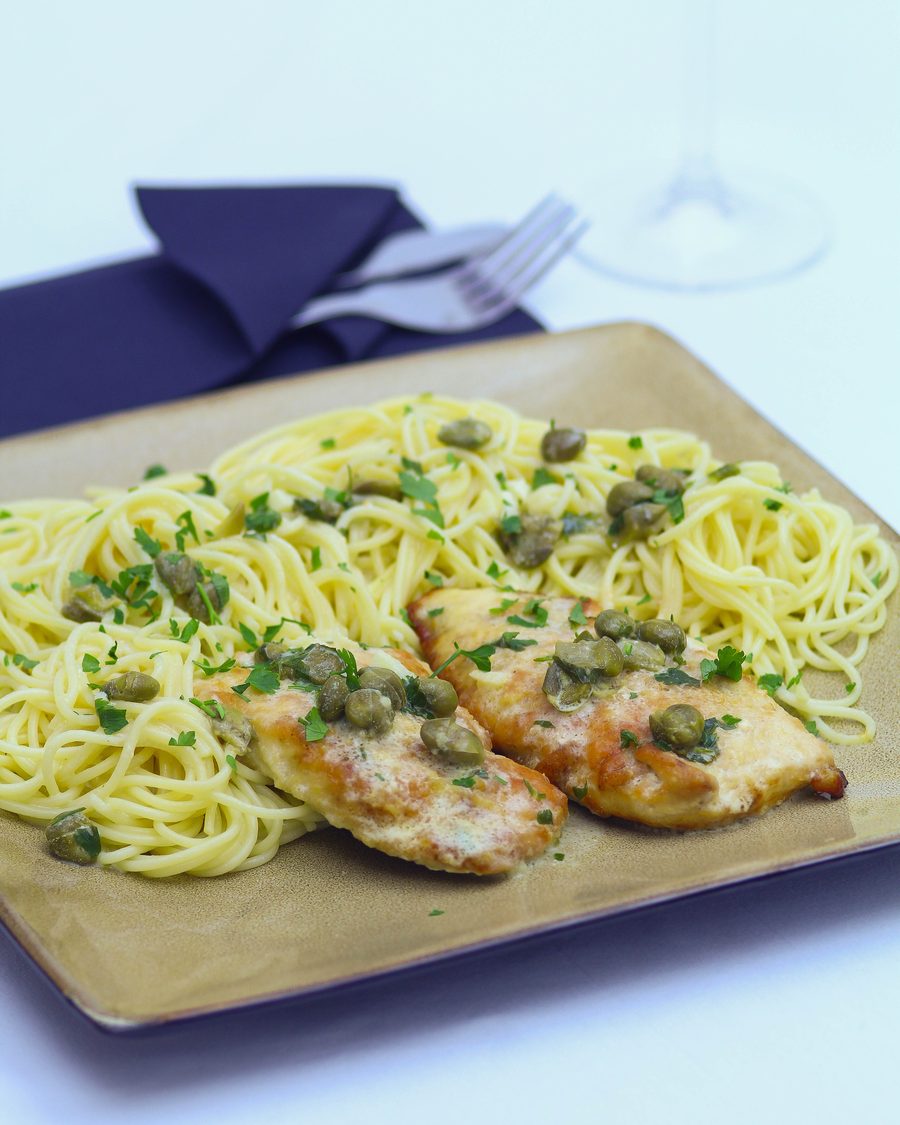 Restaurant style chicken piccata at home, served over angel hair with a glass of white wine alongside