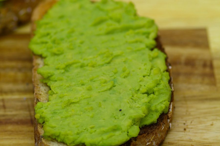 Classic avocado toast, mashed avocado and salt on toasted seeded bread