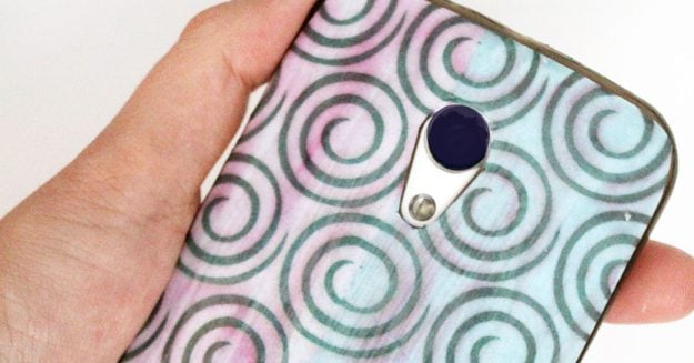 A decoupaged clear phone case with a hand cut swirl paper pattern sealed on top, a cheap handmade accessory craft to sell