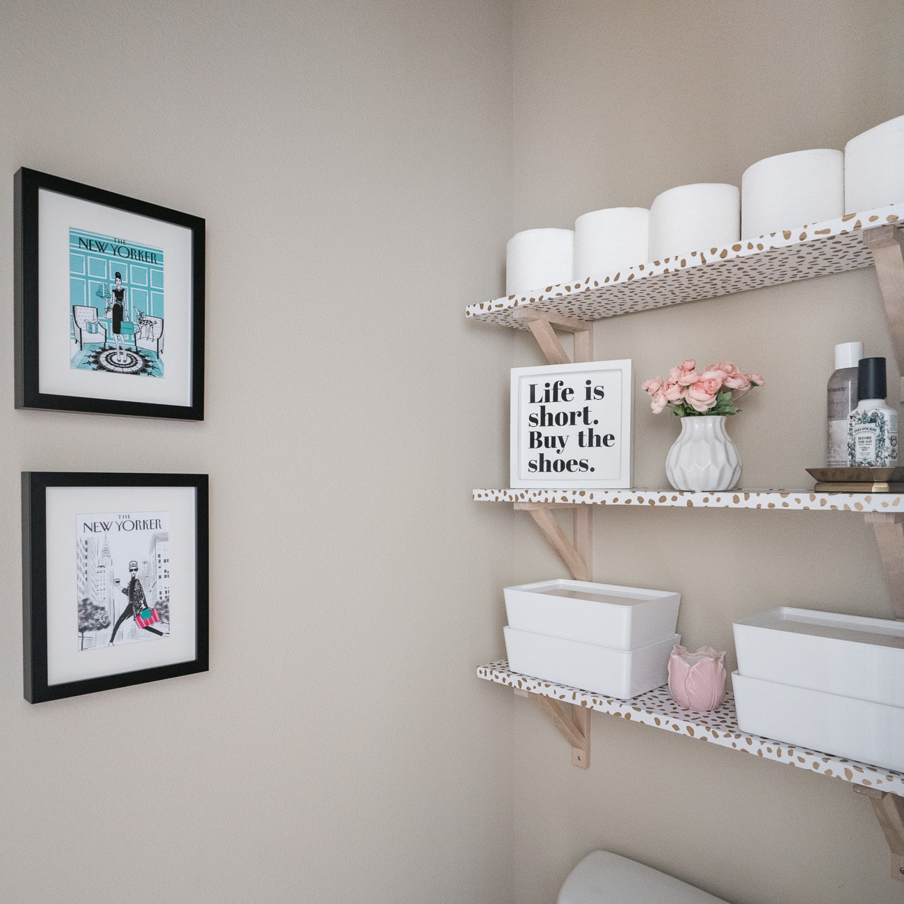 Over the toilet storage shelves in a small bathroom, a DIY bathroom decor idea using wallpaper wrapped wood