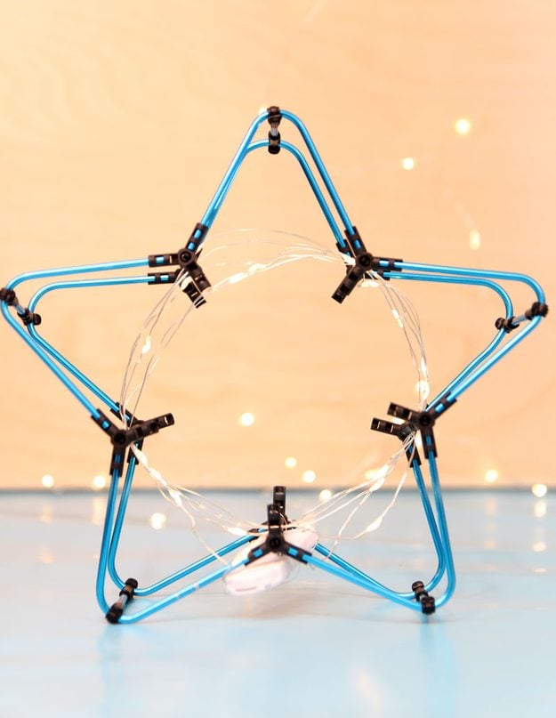 A star shaped night light built from blue aluminum smART STIX rods wrapped in a battery powered LED fairy light string
