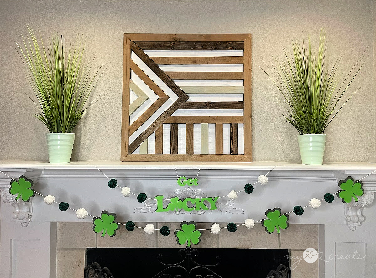 St. Patrick's Day decor, a shamrock and pom pom garland with a Get Lucky sign strung across a white mantel