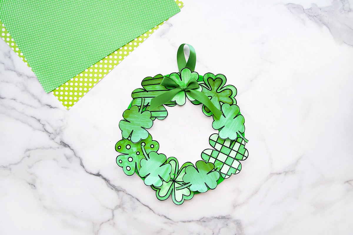 St Patricks Day decor, wreath made from overlapping green paper shamrocks with a ribbon bow and hanger