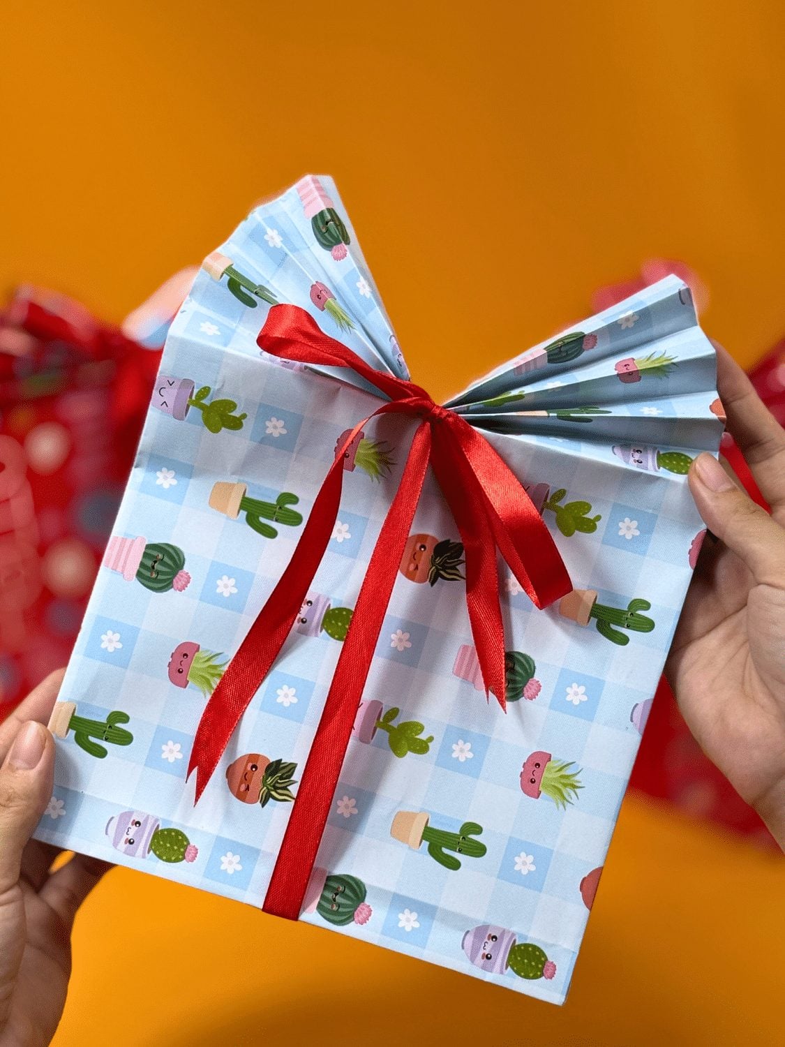 Gift Bag Folded From Wrapping Paper A handmade gift bag folded from a flat sheet of patterned wrapping paper with a pleated top and ribbon