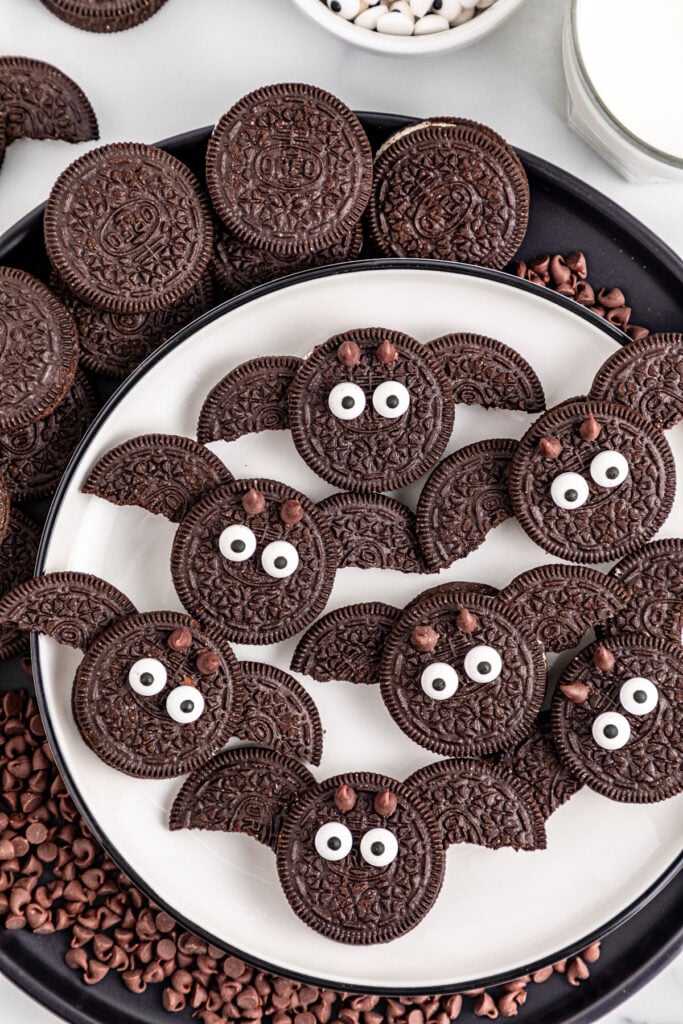 Three-Ingredient Oreo Bat Cookies Oreo bat cookies with sandwich-cookie wings, candy eyes and small pointed ears arranged on a Halloween plate