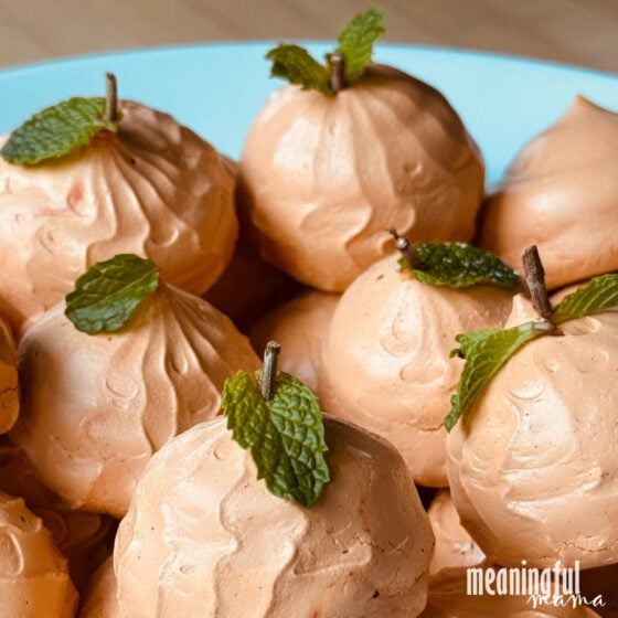 Pumpkin Spice Meringue Cookies Orange pumpkin-shaped meringue cookies piped with ridges and finished with small green stems for Halloween
