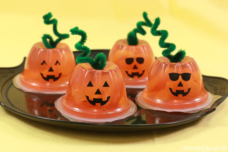Party recipe idea, kid-friendly spooky serving and savory or sweet party dish, showing jack-o'-lantern fruit cups