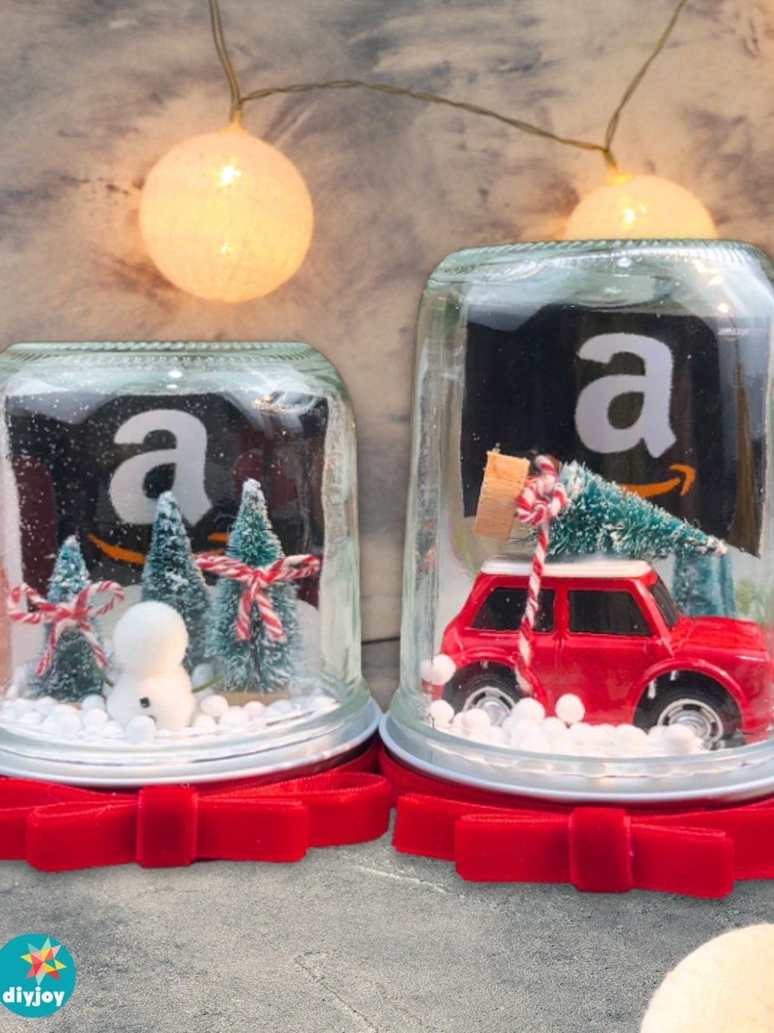 Recycled glass jar snow globe holding a gift card, filled with fake snow, glitter and a small bottle brush tree