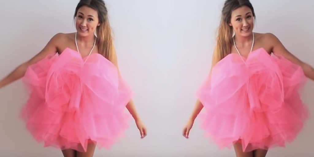 Side-by-side views of an adult wearing a voluminous bright pink bath pouf costume with a white hanging cord