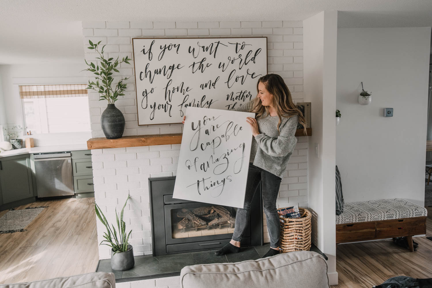 DIY bedroom wall decor, a large hand brush lettered canvas painted in black acrylic reading you are capable of amazing things