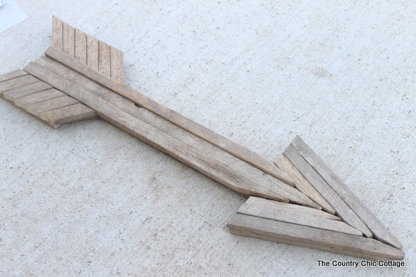 DIY wall art for the bedroom, a rustic wood arrow built from weathered gray wood slats fitted over a foam form