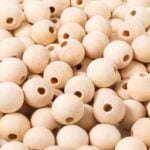 Pile of natural unfinished 14 mm wooden beads with large holes, the spacers between fabric candies on the garland