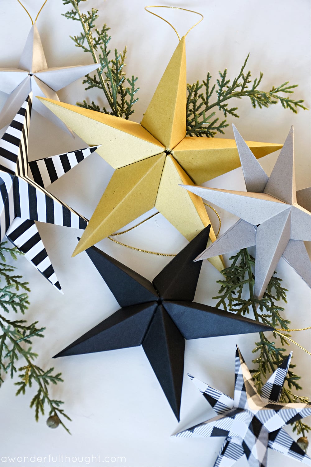 3D Paper Stars | DIY Party Decorations Idea 3D folded paper stars in gold, black, silver, black and white stripes and plaid with greenery and gold cord