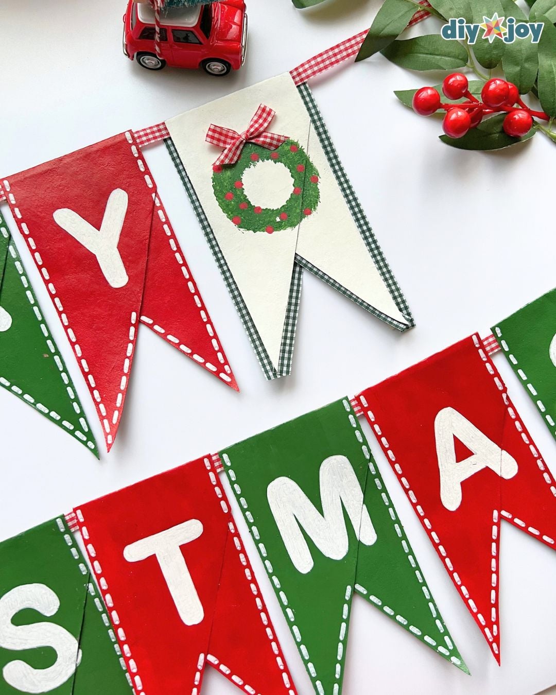 DIY holiday decor idea: a red, green and white toilet paper roll Christmas banner made from upcycled cardboard tubes