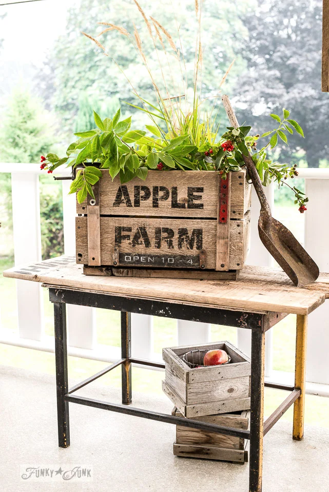 Apple decor from scrap wood, a rustic reclaimed wood crate stenciled Apple Farm on a porch with greenery and red apples