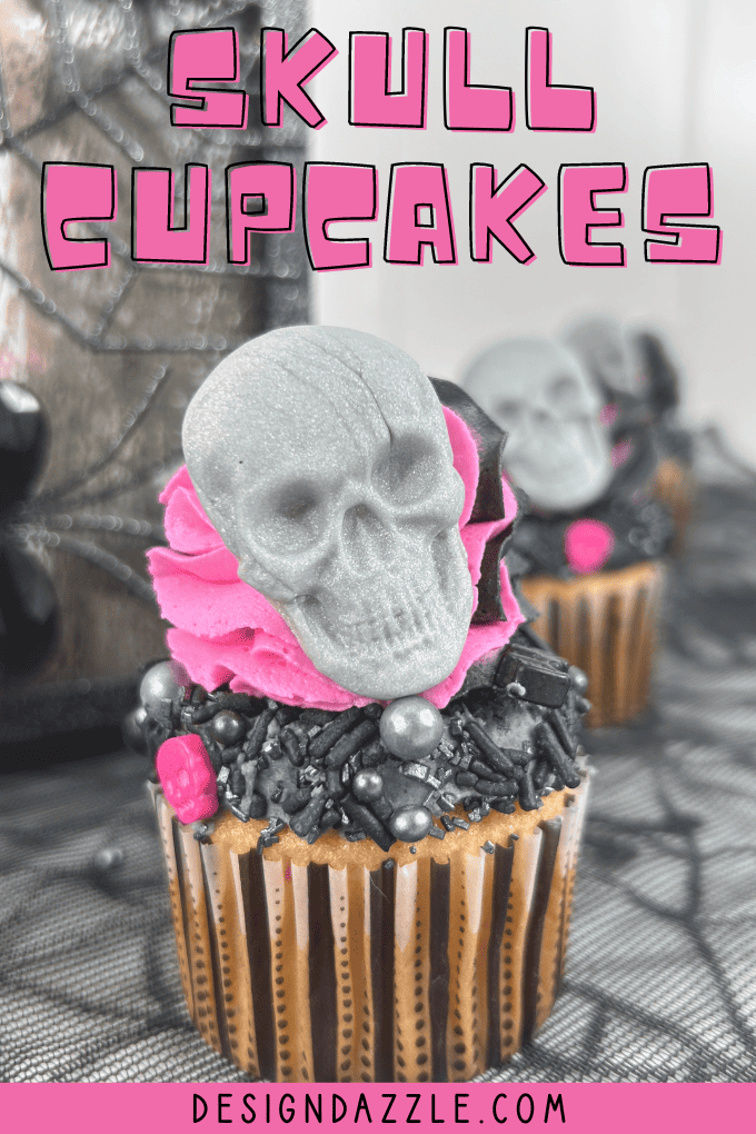 Halloween skull cupcake with hot pink and black frosting, a gray candy skull and black sprinkles