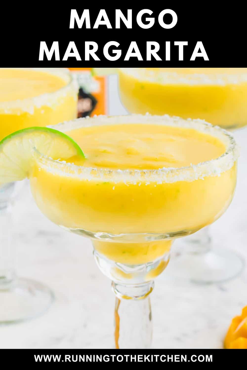 Creamy yellow mango margarita in a salt-rimmed glass with a lime wheel under the words Mango Margarita