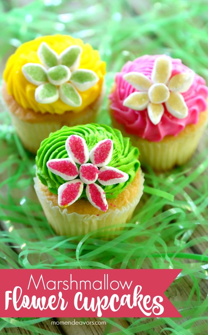 Cupcakes with bright yellow, pink and green frosting topped with flowers made from sugared marshmallow petals