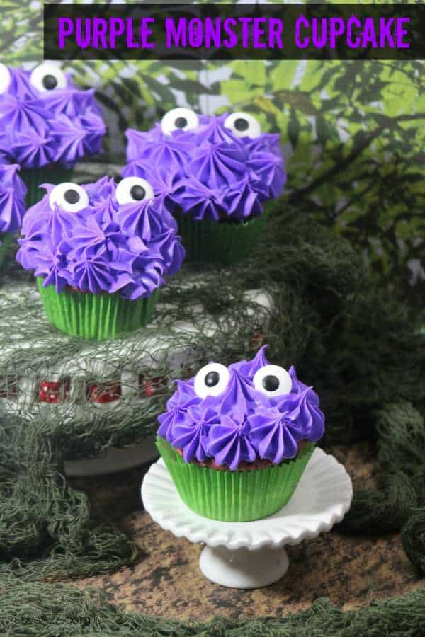 Purple cupcakes covered in shaggy piped star frosting with two candy eyes, set in a green moss scene