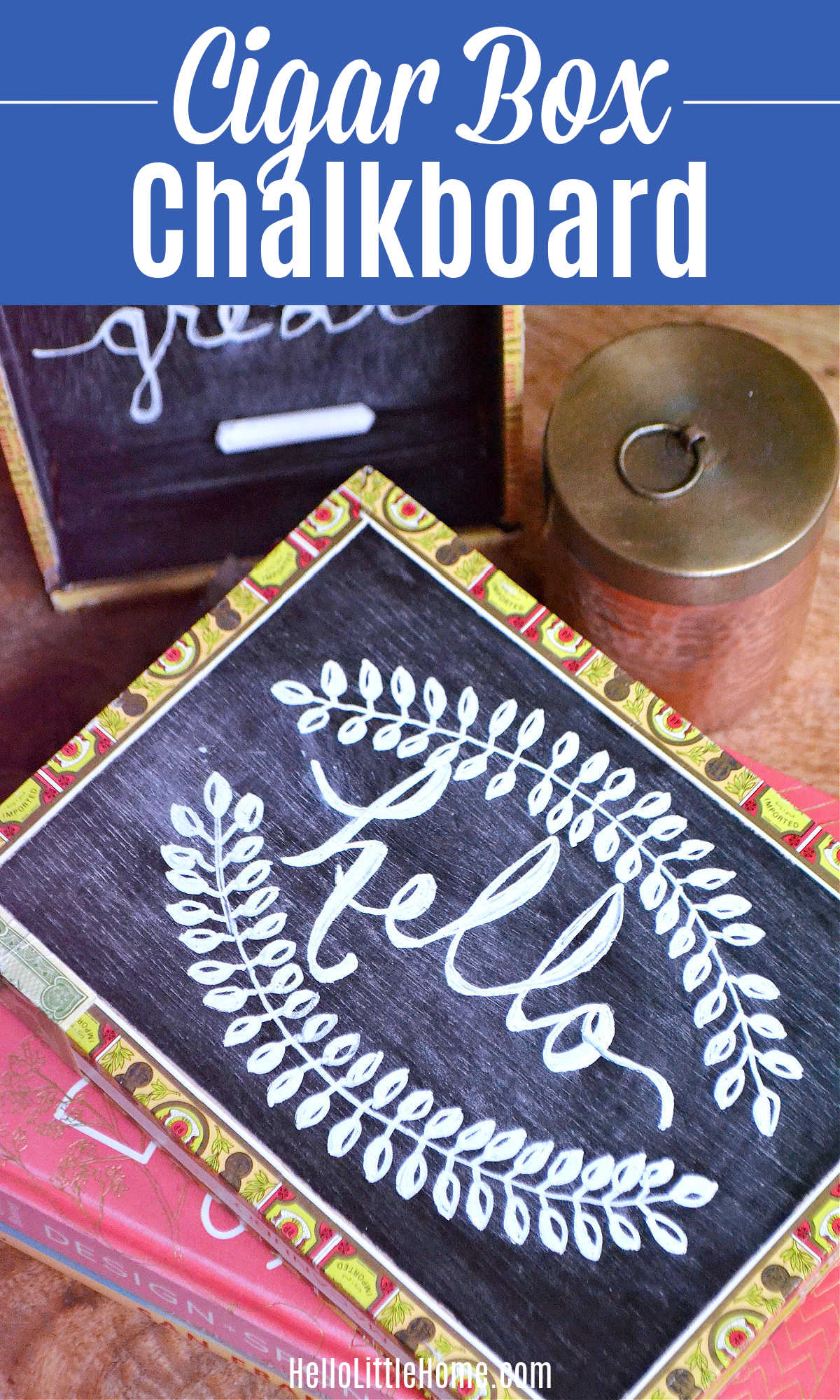 Cigar box chalkboard with patterned paper trim and hello lettered in a chalk leaf wreath, beside a copper canister