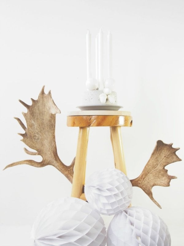 Concrete Votives and Advent Candle Holder | Holiday DIY Round white concrete taper candle holder with four white candles and white balls on a small wood stool beside antlers