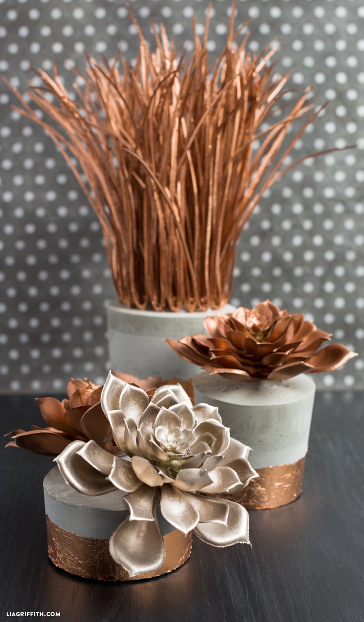 Copper Succulents in Concrete Planters | Easy DIY Three gray concrete planters with copper foil bases holding copper and silver faux succulents and copper grass