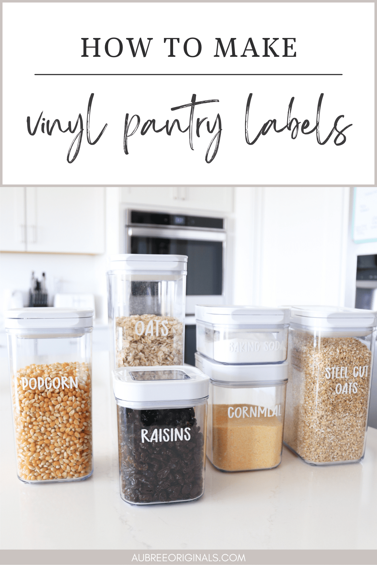 Clear pantry canisters of popcorn, oats, raisins and cornmeal with white vinyl labels on a white counter
