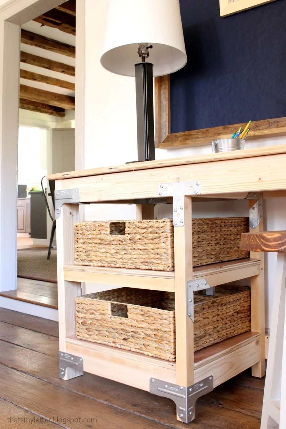 DIY workbench inspired desk with metal connector brackets, open shelves and baskets, a large wood home office desk