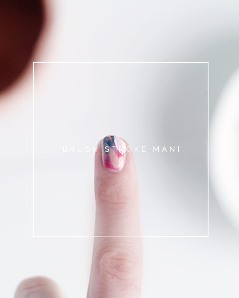 DIY Brush Stroke Abstract Mani | Quick Nail Art Idea Close up of one fingertip with an abstract brush stroke manicure in pink, navy and white over a nude base, against white