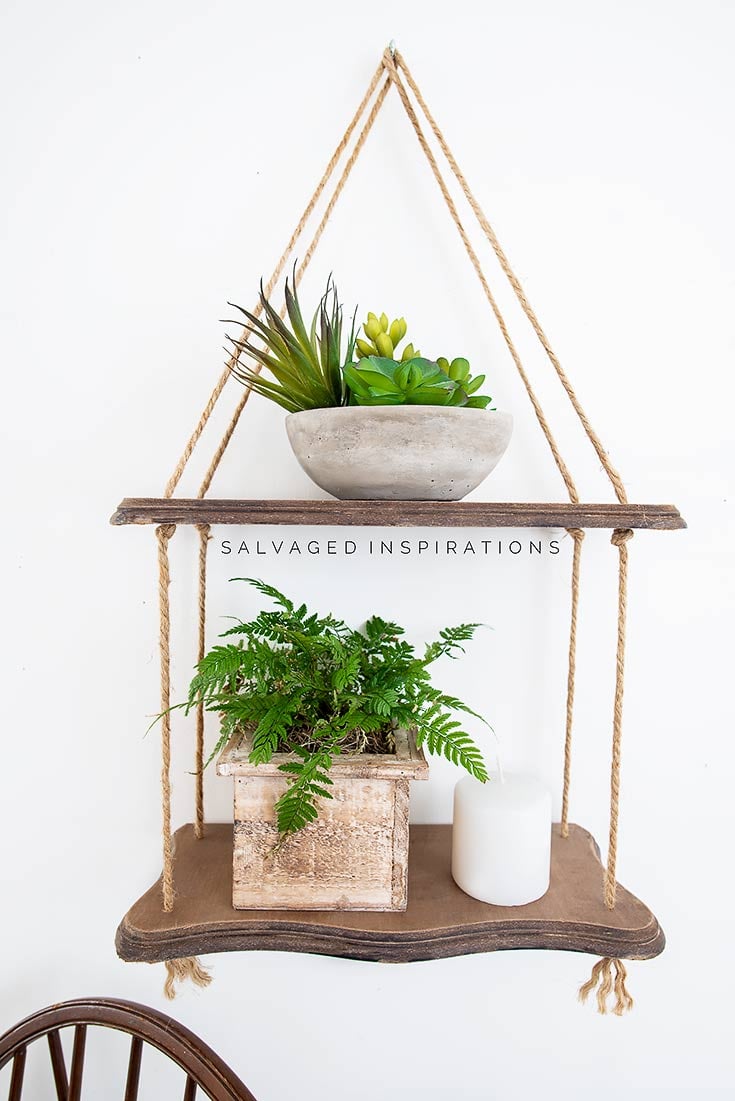 DIY hanging rope shelf, two stained wood shelves on jute rope holding succulents, a fern and a candle
