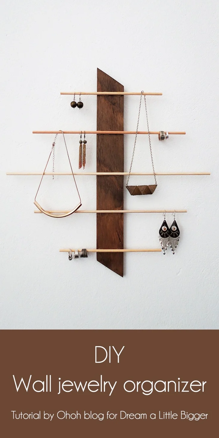 Wood and Dowel Jewelry Holder | Wall Organizer DIY Angled wood and dowel jewelry holder, a dark stained wall board with staggered wooden dowels holding earrings and necklaces