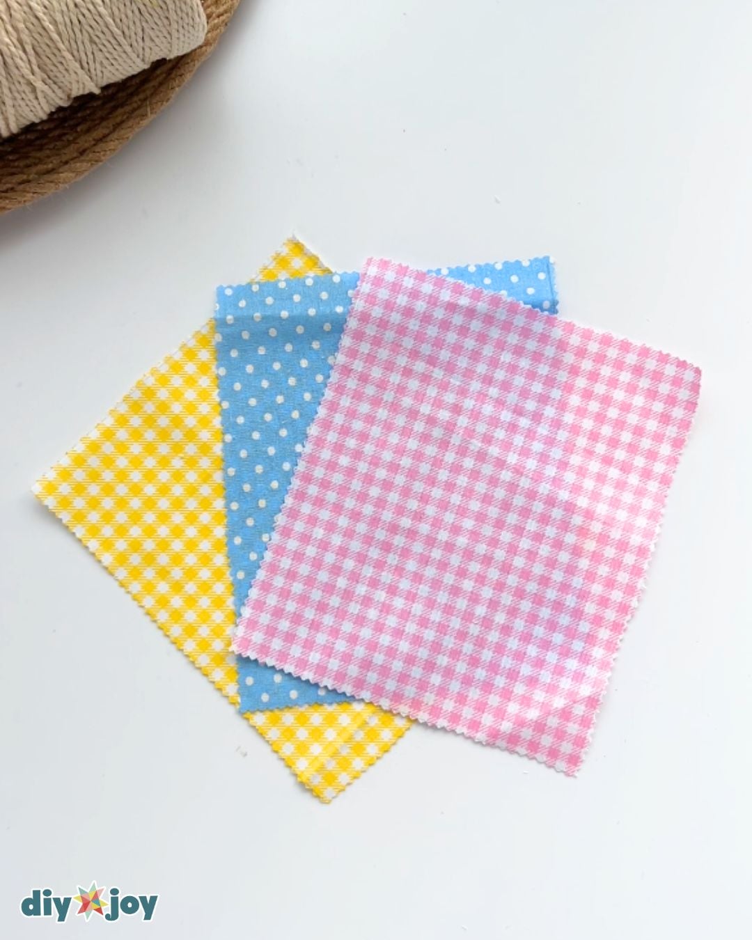 Yellow gingham, blue polka dot and pink gingham fabric rectangles cut with pinking shears for the candy garland