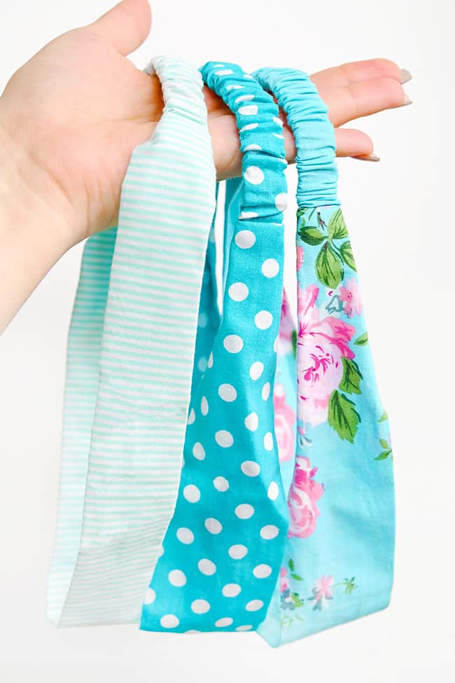 Easy Elastic Back Fabric Headbands Hand holding three fabric headbands with elastic backs in mint stripes, aqua polka dots and an aqua rose print