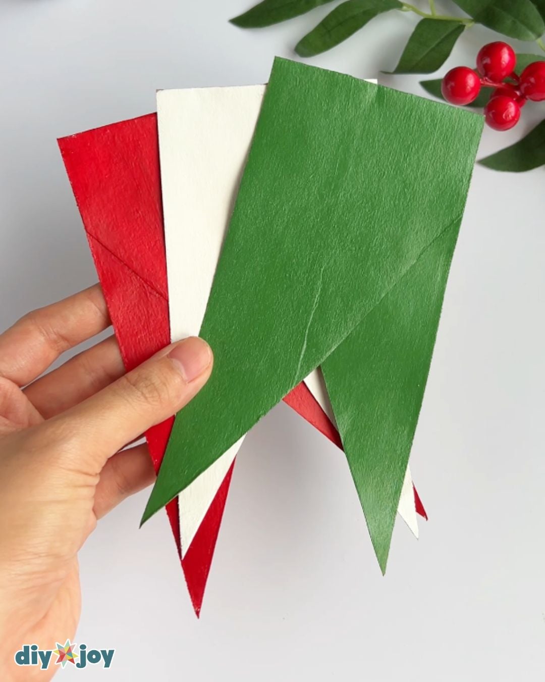 Cardboard pennants painted red, green and white, step two of a toilet paper roll Christmas banner, an easy paper craft