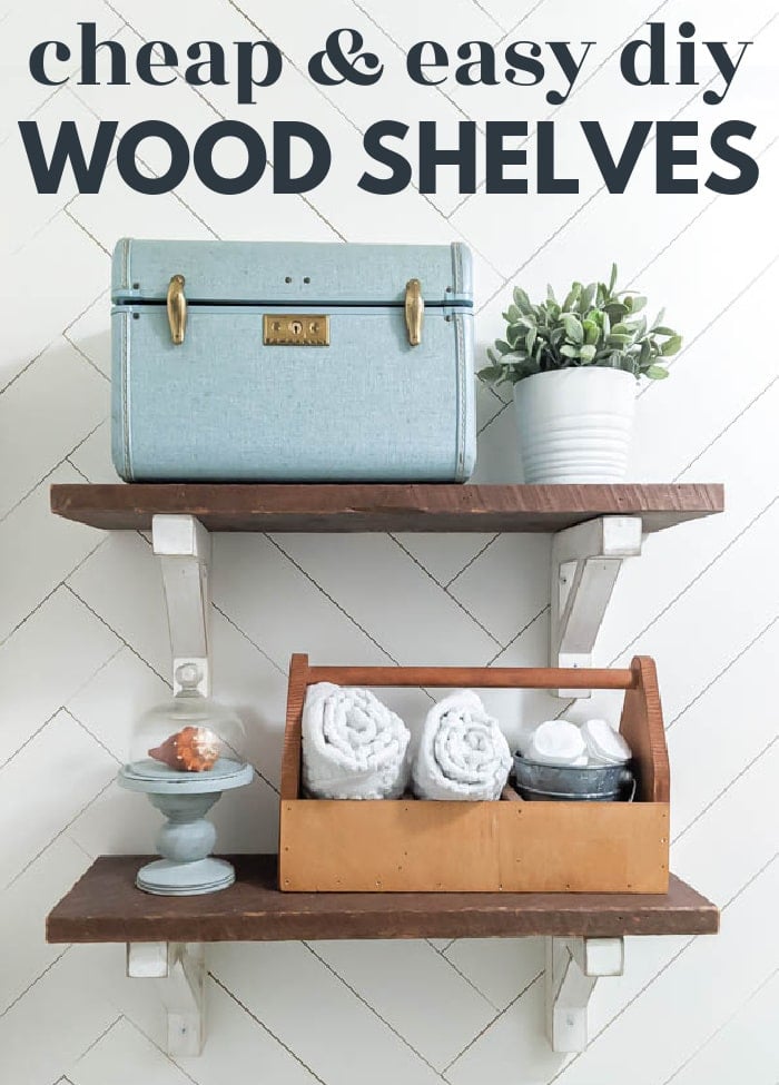 Farmhouse wood shelves, two dark reclaimed boards on white distressed brackets against a herringbone wall