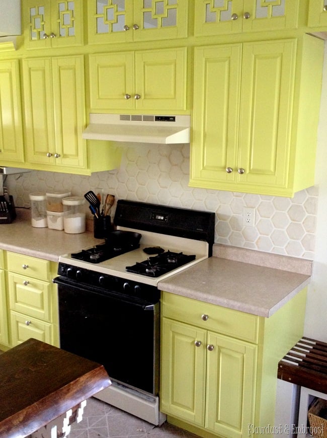 Faux Hex Tile Backsplash | Painted Stencil Look Faux hex tile painted backsplash in shimmery white with shaded hexagons behind a white stove and lime green cabinets