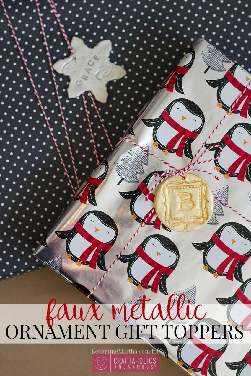 Wrapped gift in penguin paper tied with red baker's twine, topped by a gold clay B monogram and a silver star tagged Grace