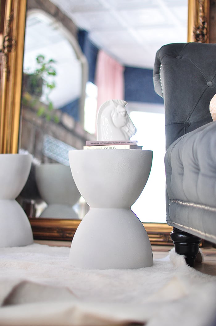 Pair of gray faux stone hourglass accent tables made with textured spray paint in front of a gold framed mirror