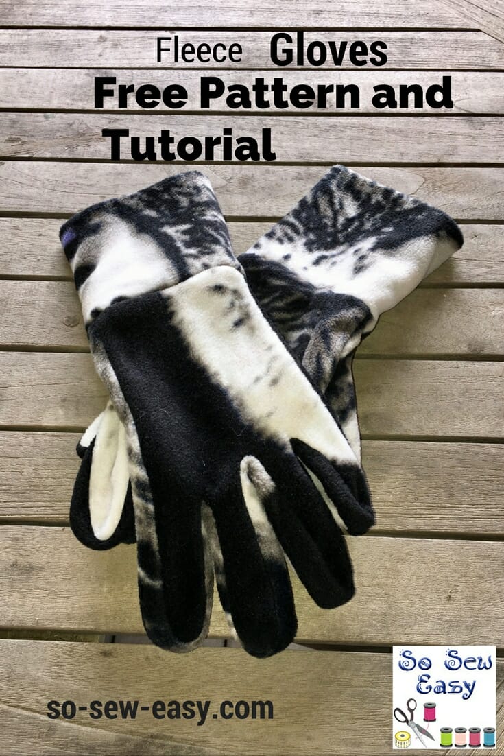 Pair of black and white fleece gloves with folded cuffs laid flat on weathered gray wooden boards under a pattern title