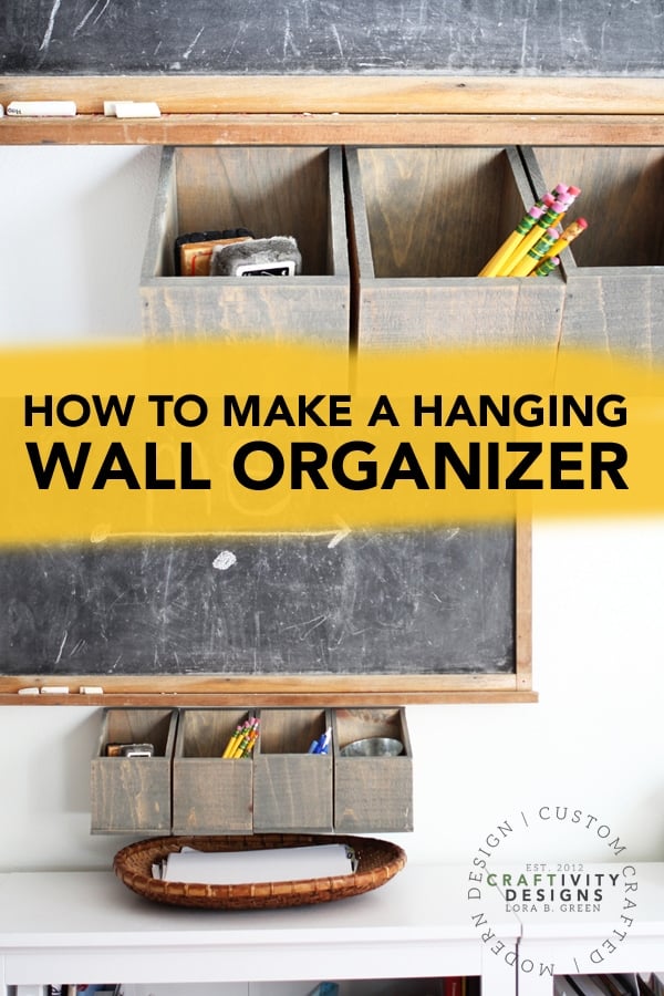 Gray stained wood box bins hung on a wall under a chalkboard, holding pencils and supplies, with a how to make text banner