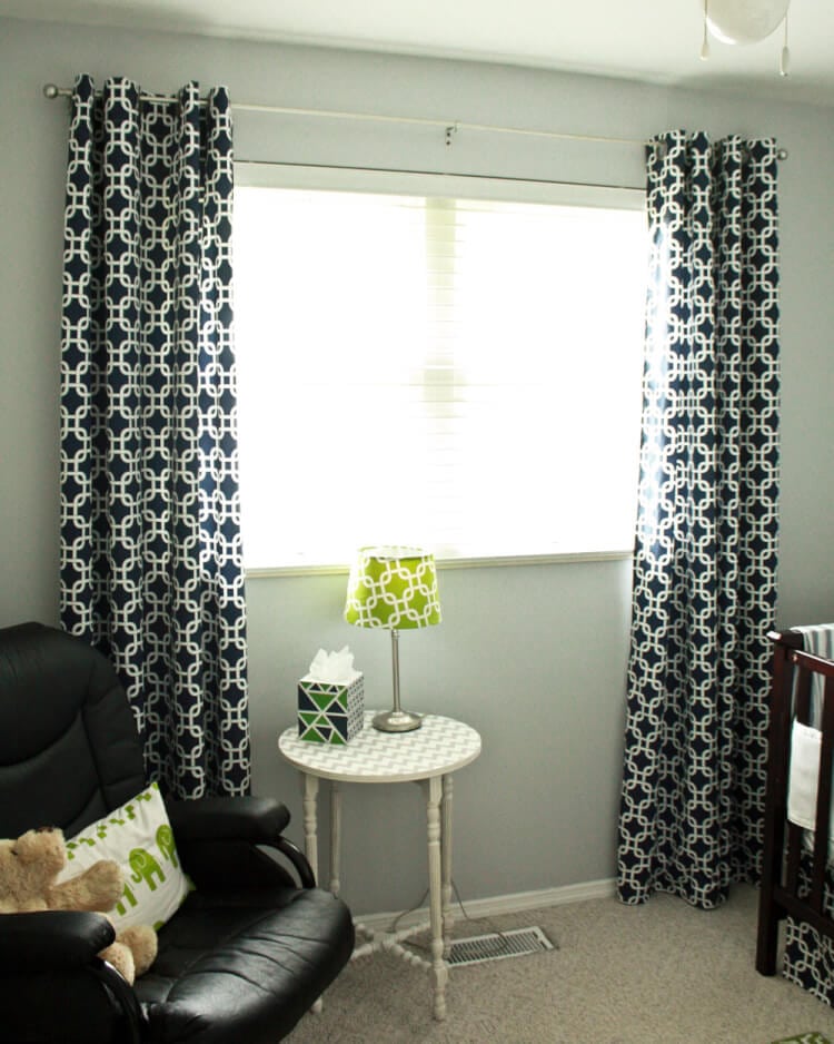 Lined Grommet Top Curtain Panels | Home Sewing Project Navy and white geometric lined grommet curtains on a rod framing a window in a nursery with a rocker and green lamp