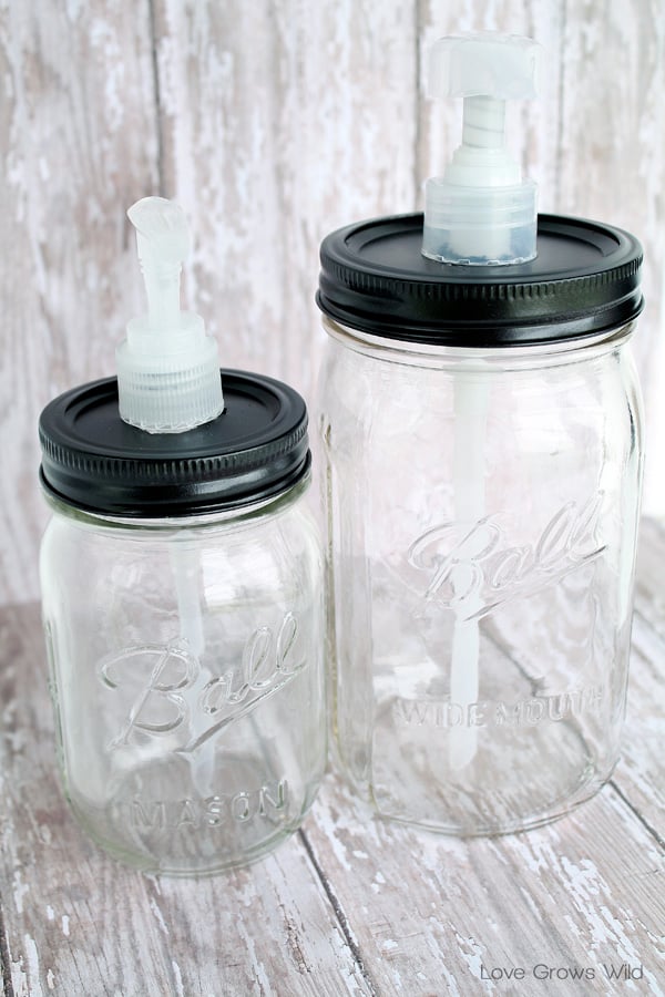 Two clear Ball mason jars, a pint and a wide mouth quart, made into soap dispensers with black lids and white pumps