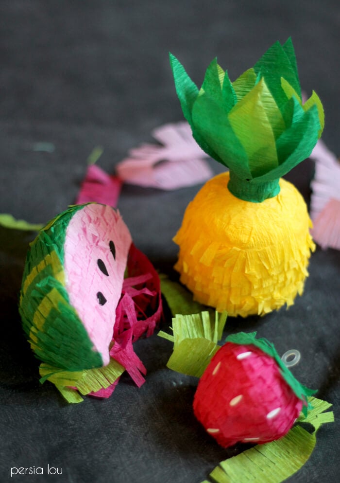Mini Fruit Pinata Garland | DIY Party Decorations Idea Mini faux pinatas shaped like a pineapple, a watermelon slice and a strawberry, made from crepe paper fringe