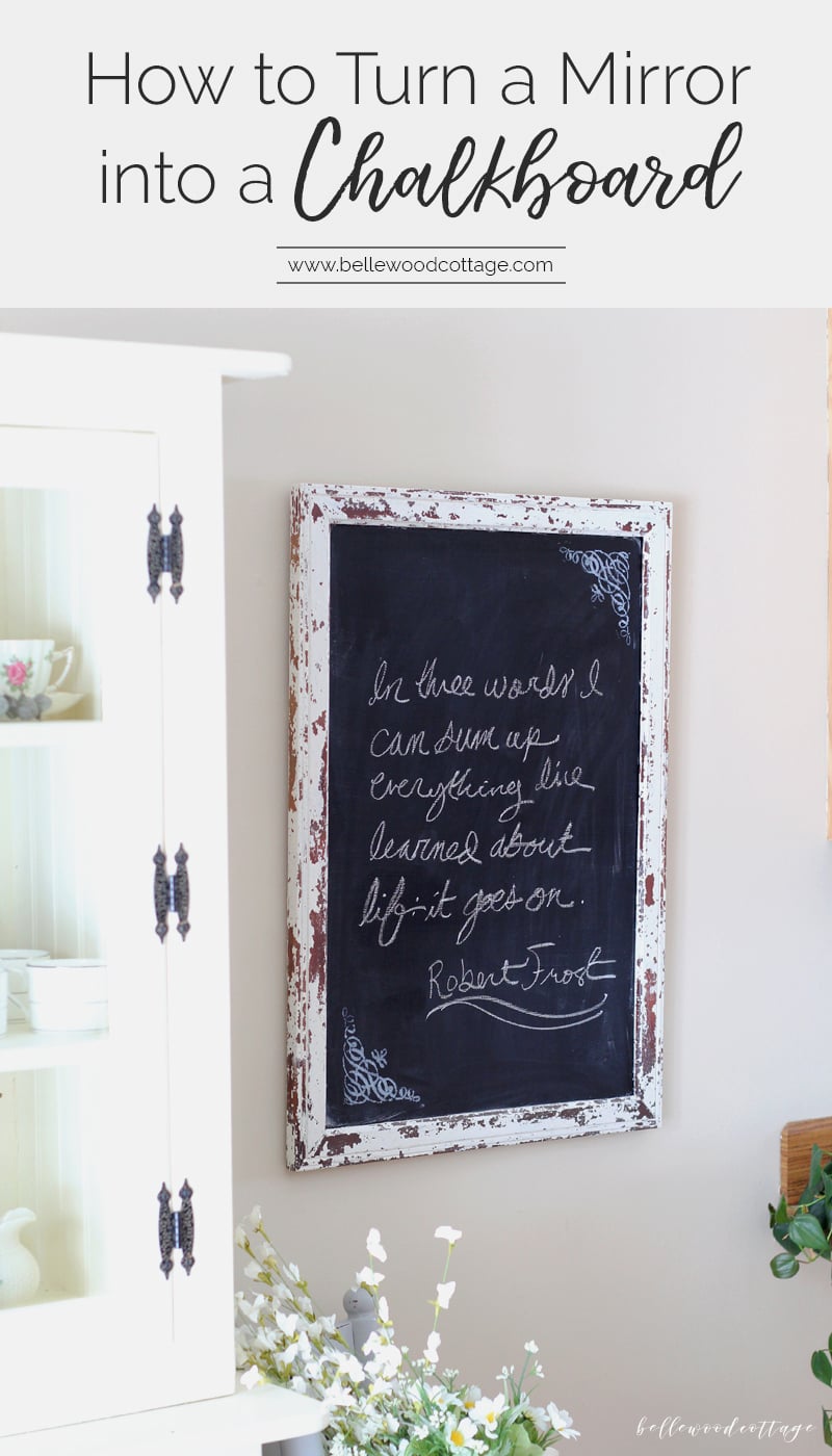 Chippy white painted mirror frame turned chalkboard with a handwritten Robert Frost quote in chalk on a light gray wall