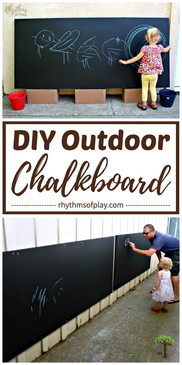 Long outdoor chalkboard panels mounted along a white fence, with an adult and a toddler drawing on them with chalk
