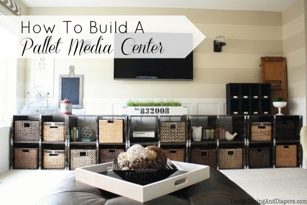Long low pallet media center with stained wood cubes full of woven baskets under a wall-mounted TV in a striped family room