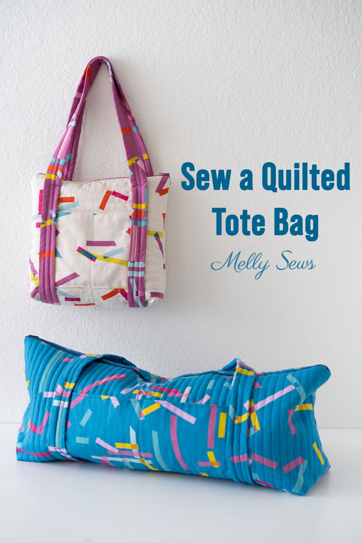 Quilted canvas tote with pink confetti print and magenta handles hanging above a matching long blue quilted duffle bag