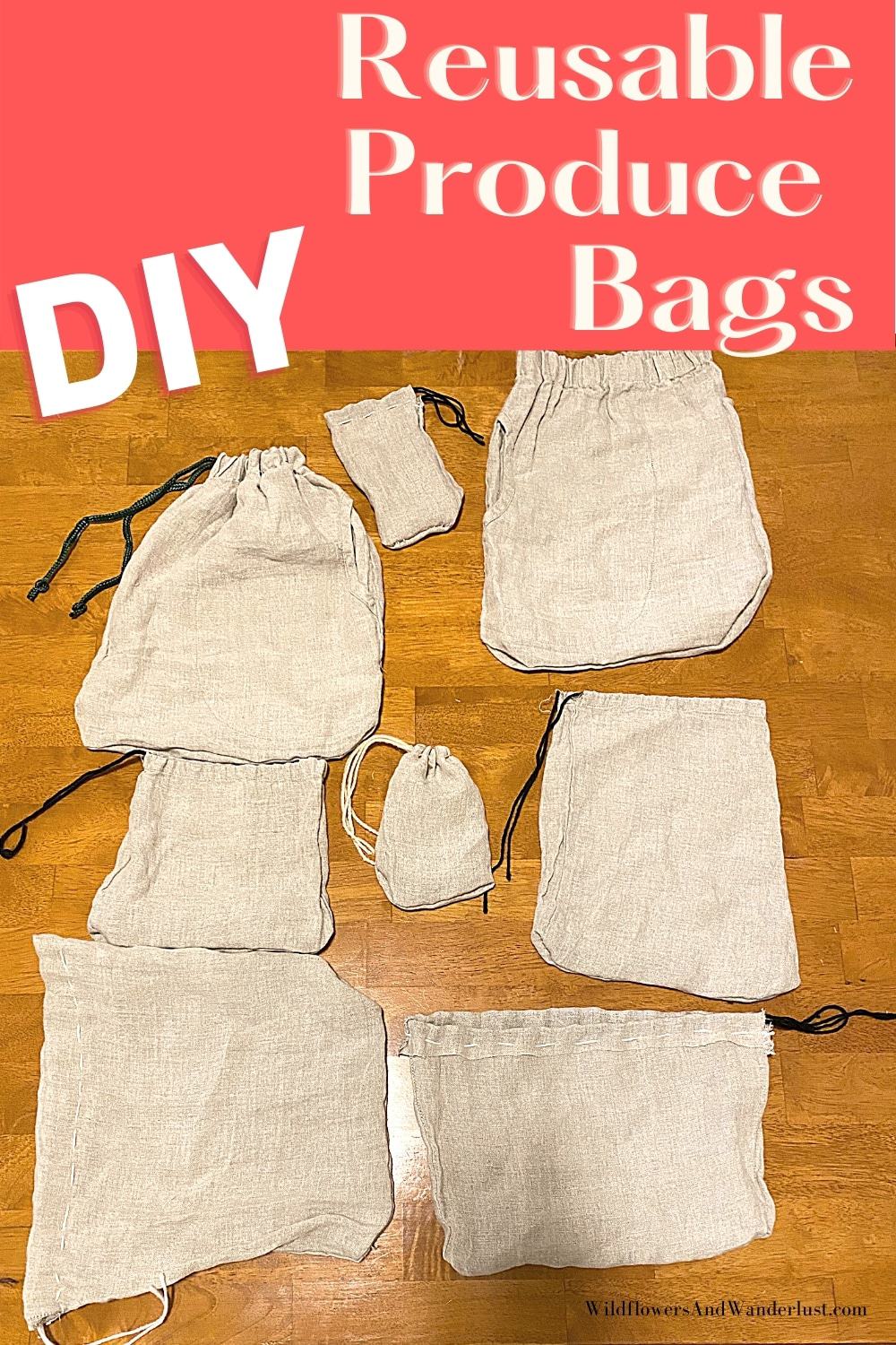 Eight homemade linen drawstring produce bags in different sizes laid flat on a wood floor, with dark cord drawstrings