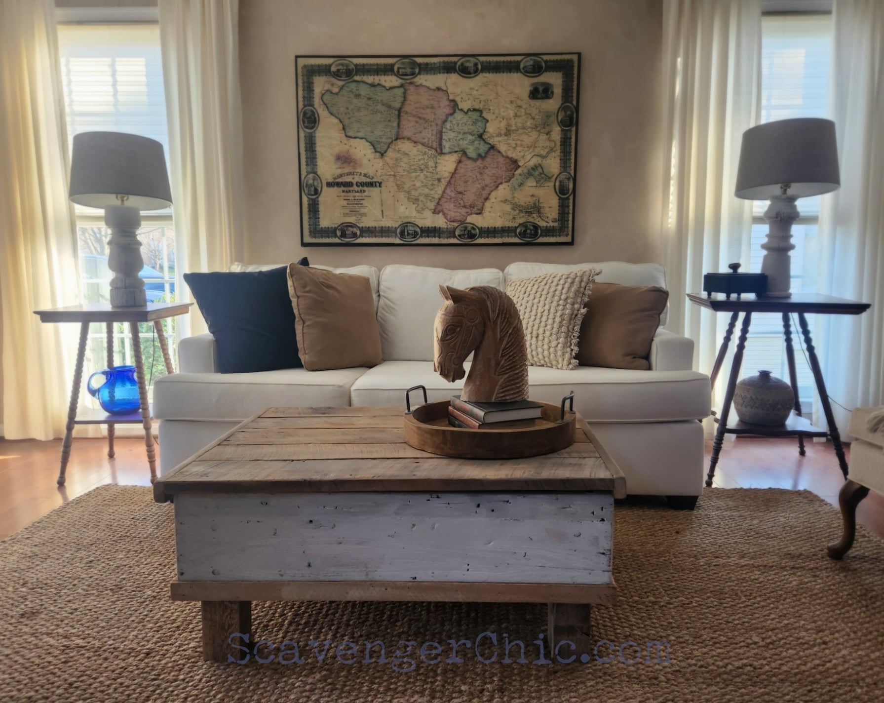 Rustic reclaimed wood plank coffee table with a lower shelf and a carved wooden horse head, in front of a cream sofa
