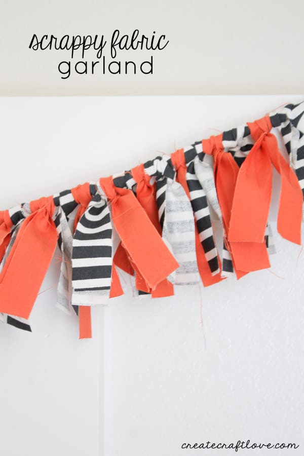 Scrappy Fabric Garland | DIY Party Decorations Idea Rag garland of orange, black and white striped fabric strips knotted onto a rope and hung against a white wall